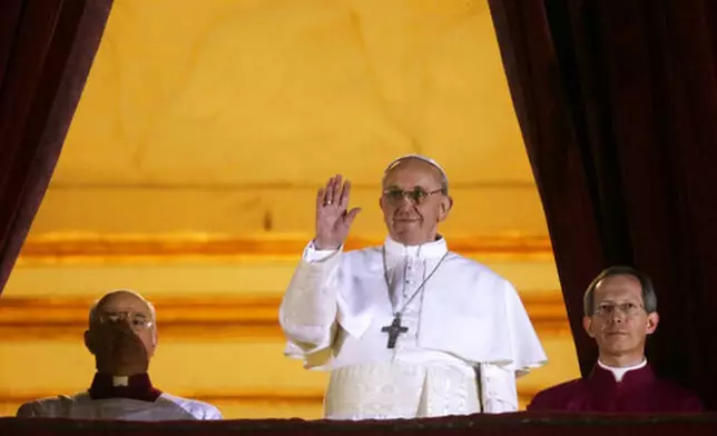 FILE - Argentine Cardinal Jorge Bergoglio, who chose the name of Pope Francis, waves to the crowd from the central balcony of St. Peter's Basilica after being elected 266th pontiff of the Roman Catholic Church, at the Vatican, Wednesday, March 13, 2013. (AP Photo/Gregorio Borgia, file)