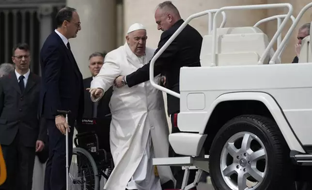 FILE - Pope Francis helped to get on his car at the end of weekly general audience in St. Peter's Square, at the Vatican, Wednesday, March 29, 2023. (AP Photo/Alessandra Tarantino, File)