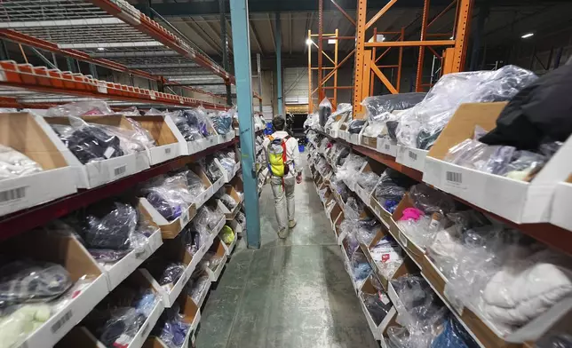 Bags of returned or overstocked clothing, shoes, boots, coats, packs and other items sit in a fulfillment warehouse after the goods were cleaned or repaired to be marketed on resale platforms in Englewood, Colo., on Thursday, April 17, 2025. (AP Photo/David Zalubowski)