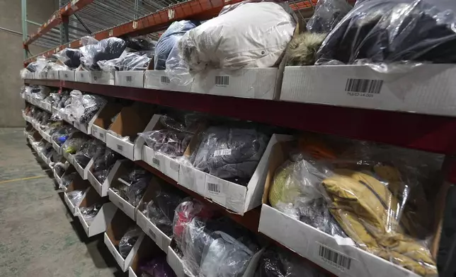Bags of returned or overstocked clothing, shoes, boots, coats, packs and other items sit in a fulfillment warehouse after the goods were cleaned or repaired as they are marketed on resale platforms Thursday, April 17, 2025, in Englewood, Colo. (AP Photo/David Zalubowski)