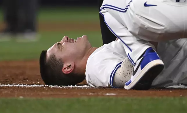 Toronto Blue Jays left fielder Alan Roden lies on the field after colliding with Seattle Mariners first baseman Rowdy Tellez (23) in fifth inning American League baseball action in Toronto on Saturday, April 19, 2025. (Jon Blacker/The Canadian Press via AP)