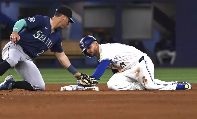 Toronto Blue Jays second baseman Andres Gimenez, right, slides safely into second base with a steal ahead of a tag from Seattle Mariners second baseman Dylan Moore (25) in fifth inning American League baseball action in Toronto on Saturday, April 19, 2025. (Jon Blacker/The Canadian Press via AP)