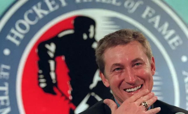 FILE - Hockey legend Wayne Gretzky laughs as he wears his new Hockey Hall of Fame ring during his induction ceremony at the Hall in Toronto, Nov. 22, 1999. (AP Photo/Frank Gunn, File)