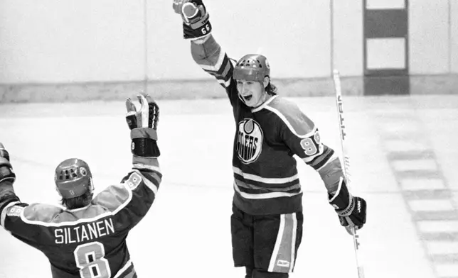 FILE - Edmonton Oilers Wayne Gretzky, right, shows his joy after registering his fourth goal during an NHL hockey game against the Philadelphia Flyers in Philadelphia, March 7, 1981, as teammate Risto Siltanen comes to congratulate him. (AP Photo/Clem Murray, File)