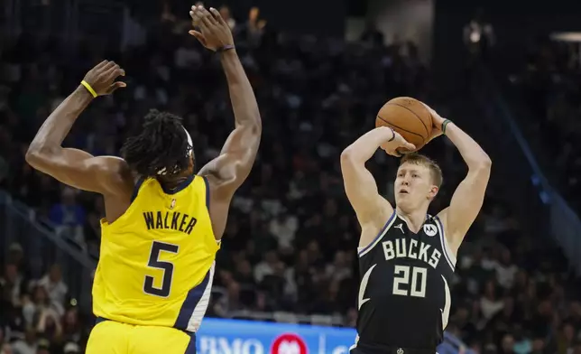 Milwaukee Bucks' AJ Green (20) shoots against the Indiana Pacers' Jarace Walker trying to save a ball against the Indiana Pacers during the first half of Game 4 of a first-round NBA basketball playoff series Sunday, April 27, 2025, in Milwaukee. (AP Photo/Jeffrey Phelps)
