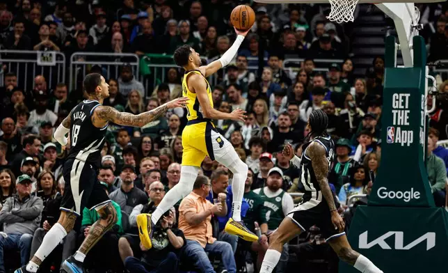 Indiana Pacers' Tyrese Haliburton, middle, puts up a shot against the Milwaukee Bucks during the first half of Game 4 of a first-round NBA basketball playoff series Sunday, April 27, 2025, in Milwaukee. (AP Photo/Jeffrey Phelps)