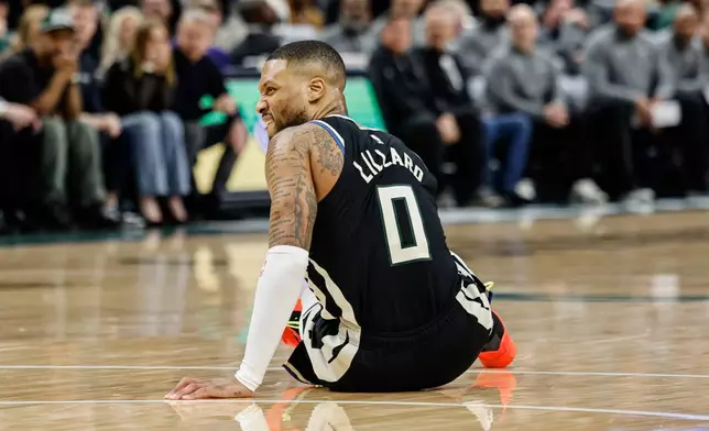 Milwaukee Bucks' Damian Lillard grimaces as he falls to the floor against the Indiana Pacers during the first half of Game 4 of a first-round NBA basketball playoff series Sunday, April 27, 2025, in Milwaukee. (AP Photo/Jeffrey Phelps)