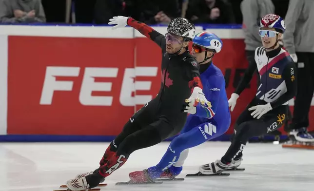 Canada's William Dandjinou celebrates after winning the gold medal in the men's 1000 meters final of the ISU Short Track World Tour and Milan Cortina 2026 Winter Olympics test event, in Milan, Italy, Sunday, Feb. 16, 2025. (AP Photo/Luca Bruno)
