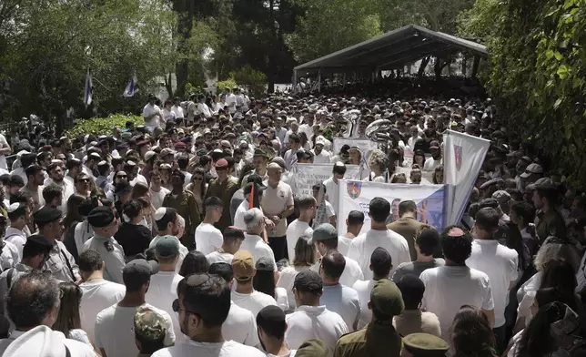 People and Israeli soldiers stand during two minutes of silence as air raid sirens sound marking the Israel's annual Memorial Day for the fallen soldiers and victims of nationalistic attacks at Mount Herzl military cemetery in Jerusalem, Wednesday, April 30, 2025. (AP Photo/Maya Alleruzzo)