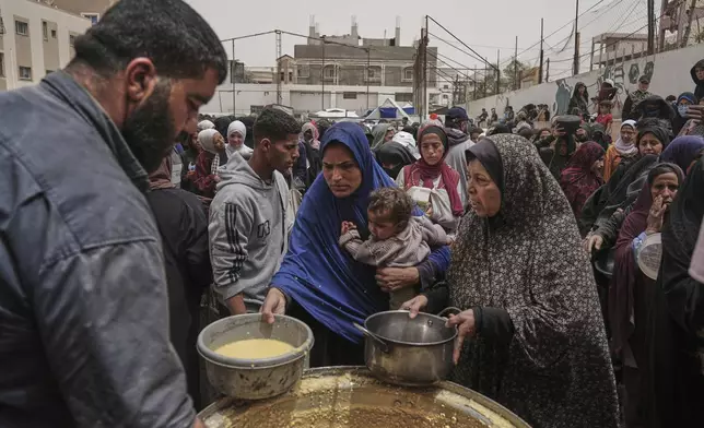 Palestinians receive donated food at a distribution center in Nuseirat, central Gaza Strip, Wednesday, April 30, 2025. (AP Photo/Abdel Kareem Hana)