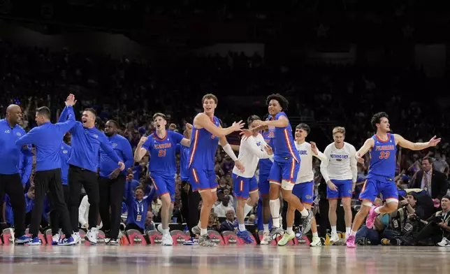 Florida celebrates their win against Auburn in the national semifinals at the Final Four of the NCAA college basketball tournament, Saturday, April 5, 2025, in San Antonio. (AP Photo/Brynn Anderson)