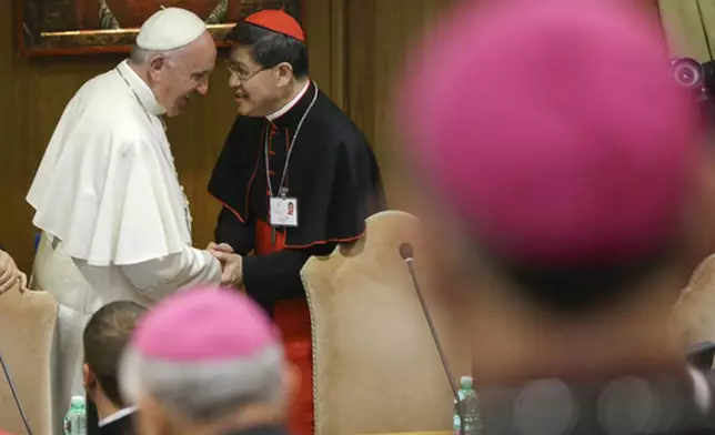 FILE - In this Monday, Oct. 5, 2015 file photo, Pope Francis is greeted by Cardinal Luis Antonio Tagle, right, upon his arrival at the opening session of a two-week bishops' meeting on family issues, at the Vatican. (AP Photo/Alessandra Tarantino, File)