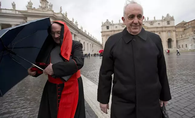 FILE - Canadian Cardinal Marc Ouellet, left, holds on to his umbrella next to Argentine Cardinal Jorge Mario Bergoglio as they walk in St. Peter's Square after attending a cardinals' meeting, at the Vatican, Wednesday, March 6, 2013. (AP Photo/Andrew Medichini, File)