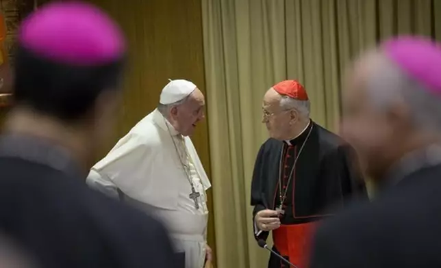 FILE - Pope Francis, left, talks with Cardinal Peter Erdo of Hungary as arrives for the afternoon session of a two-week synod on family issues at the Vatican, Monday, Oct. 6, 2014. (AP Photo/Alessandra Tarantino, File)