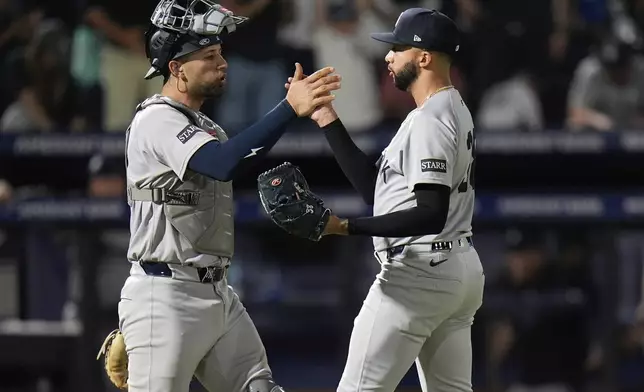 New York Yankees pitcher Devin Williams, right, celebrates with catcher J.C. Escarra after closing out the Tampa Bay Rays during the ninth inning of a baseball game Thursday, April 17, 2025, in Tampa, Fla. (AP Photo/Chris O'Meara)