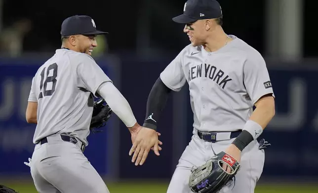 New York Yankees infielder Oswald Peraza (18) and outfielder Aaron Judge celebrate after the team defeated the Tampa Bay Rays during a baseball game Thursday, April 17, 2025, in Tampa, Fla. (AP Photo/Chris O'Meara)