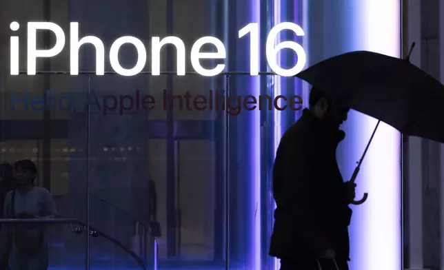 A person carrying an umbrella walks past the Apple Store on the 5th Avenue, Monday, April 7, 2025, in New York. (AP Photo/Yuki Iwamura)