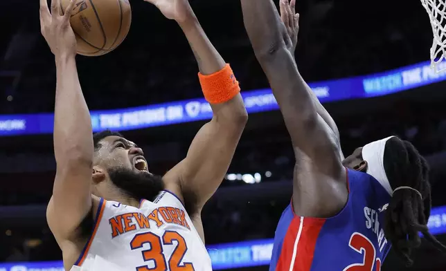 New York Knicks center Karl-Anthony Towns (32) goes to the basket against Detroit Pistons center Isaiah Stewart, right, during the first half of an NBA basketball game Thursday, April 10, 2025, in Detroit. (AP Photo/Duane Burleson)
