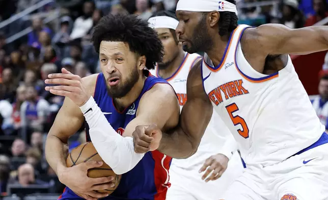 Detroit Pistons guard Cade Cunningham, left, drives to the basket against New York Knicks forward Precious Achiuwa (5) during the second half of an NBA basketball game Thursday, April 10, 2025, in Detroit. (AP Photo/Duane Burleson)