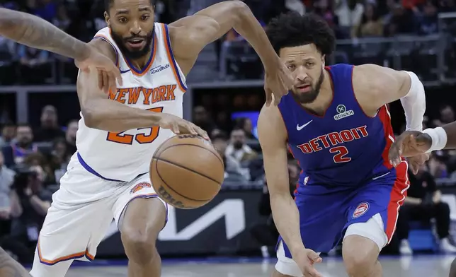 New York Knicks forward Mikal Bridges, left, drives the lane past Detroit Pistons guard Cade Cunningham (2) during the first half of an NBA basketball game Thursday, April 10, 2025, in Detroit. (AP Photo/Duane Burleson)