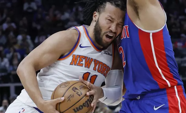 New York Knicks guard Jalen Brunson (11) collides with Detroit Pistons guard Cade Cunningham while going to the basket during the first half of an NBA basketball game Thursday, April 10, 2025, in Detroit. (AP Photo/Duane Burleson)