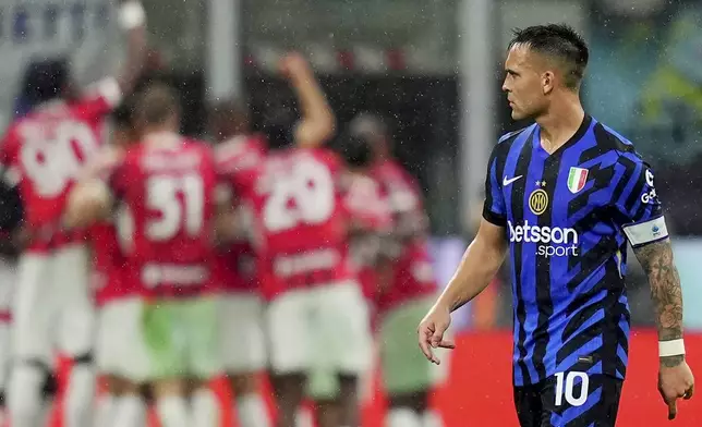 Inter Milan's Lautaro Martinez walks off as AC Milan players celebrate during the Italian Cup semifinal second leg soccer match between Inter Milan and AC Milan at the San Siro stadium in Milan, Italy, Wednesday, April 23, 2025. (Spada/LaPresse via AP)