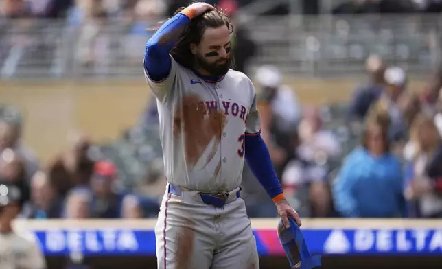 New York Mets' Jesse Winker (3) walks back to the dugout after being thrown out at home plate during the second inning of a baseball game against the Minnesota Twins, Wednesday, April 16, 2025, in Minneapolis. (AP Photo/Abbie Parr)