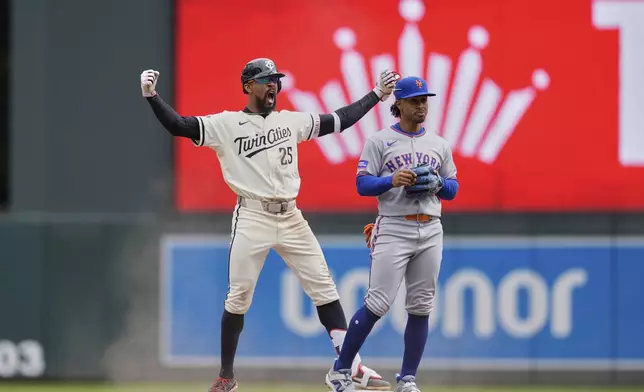 Minnesota Twins' Byron Buxton (25), left, celebrates next to New York Mets shortstop Francisco Lindor (12) after hitting an RBI-single during the fifth inning of a baseball game, Wednesday, April 16, 2025, in Minneapolis. (AP Photo/Abbie Parr)
