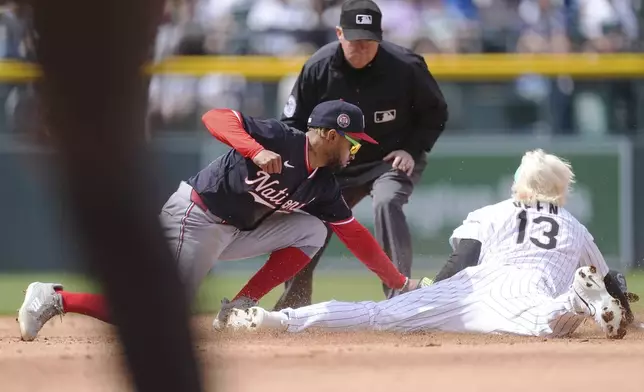 Washington Nationals shortstop Nasim Nuñez, left, applies a late tag as Colorado Rockies' Zac Veen steals second base as umpire Todd Tichenor waits to make the call in the fifth inning of Game 1 of a split baseball doubleheader Sunday, April 20, 2025, in Denver. (AP Photo/David Zalubowski)
