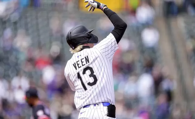 Colorado Rockies' Zac Veen gestures to the bullpen after hitting a solo home run off Washington Nationals starting pitcher Jake Irvin in the fourth inning of Game 1 of a split baseball doubleheader Sunday, April 20, 2025, in Denver. (AP Photo/David Zalubowski)