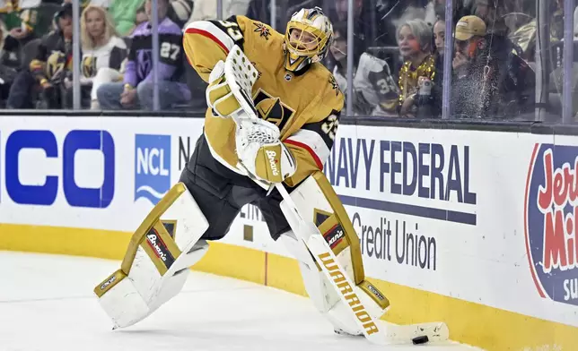 Vegas Golden Knights goaltender Adin Hill (33) handles the puck against the Minnesota Wild during the third period of Game 5 of a first-round NHL hockey playoff series Tuesday, April 29, 2025, in Las Vegas. (AP Photo/David Becker)