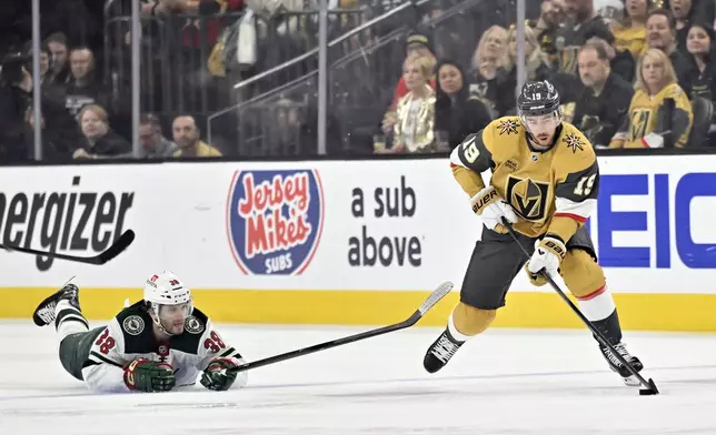 Minnesota Wild right wing Ryan Hartman (38) falls to the ice chasing Vegas Golden Knights right wing Reilly Smith (19) during the first period of Game 5 of a first-round NHL hockey playoff series Tuesday, April 29, 2025, in Las Vegas. (AP Photo/David Becker)