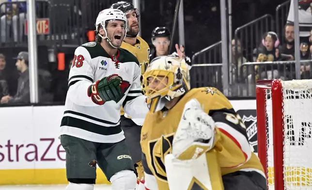 Minnesota Wild right wing Ryan Hartman (38) reacts after a goal by left wing Kirill Kaprizov against Vegas Golden Knights goaltender Adin Hill (33) during the first period of Game 5 of a first-round NHL hockey playoff series Tuesday, April 29, 2025, in Las Vegas. (AP Photo/David Becker)