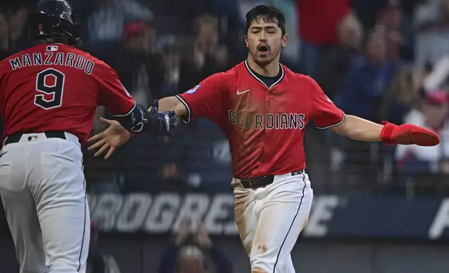Cleveland Guardians' Steven Kwan, right, is congratulated by Kyle Manzardo after scoring a run on a pass ball by New York Yankees relief pitcher Mark Leiter Jr. during the sixth inning of a baseball game Tuesday, April 22, 2025, in Cleveland. (AP Photo/David Dermer)