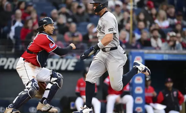 New York Yankees' Aaron Judge scores a run on a sacrifice by Jazz Chisholm Jr. during the sixth inning of a baseball game, Tuesday, April 22, 2025, in Cleveland. (AP Photo/David Dermer)