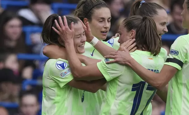 Barcelona's Claudia Pina, left, is congratulated by Ewa Pajor after scoring her side's third goal during the women's Champions League semifinals, second leg, soccer match between Chelsea FC and FC Barcelona at Stamford Bridge in London, Sunday, April 27, 2025. (AP Photo/Dave Shopland)