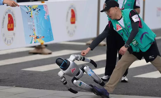 A robot loses control at the start in what is billed as the world's first robot half marathon during the Humanoid Robot Half-Marathon held in Beijing on Saturday, April 19, 2025. (AP Photo/Ng Han Guan)