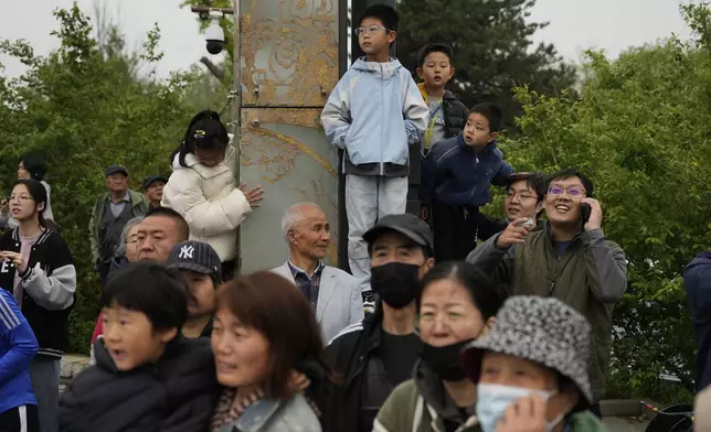 People watch the Humanoid Robot Half-Marathon held in Beijing on Saturday, April 19, 2025. (AP Photo/Ng Han Guan)