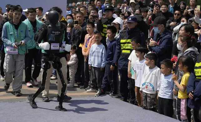 A robot from DroidUp walks to the award ceremony after winning the second runner up position in the Humanoid Robot Half-Marathon held in Beijing on Saturday, April 19, 2025. (AP Photo/Ng Han Guan)