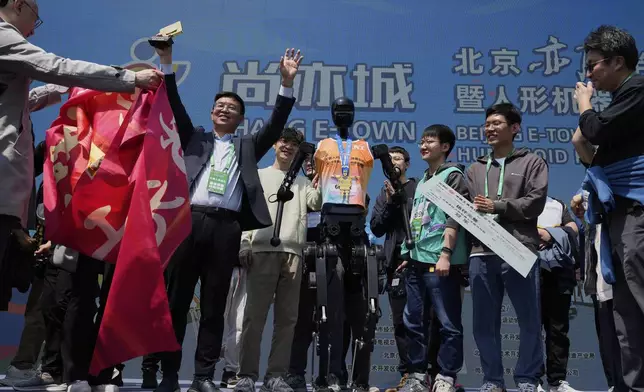 The team behind the Sky Project Ultra robot also known as Tien Kung Ultra celebrate after winning the Humanoid Robot Half-Marathon held in Beijing on Saturday, April 19, 2025. (AP Photo/Ng Han Guan)