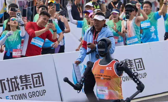 The Sky Project Ultra robot also known as Tien Kung Ultra crosses the finish line to win the Humanoid Robot Half-Marathon held in Beijing on Saturday, April 19, 2025. (AP Photo/Ng Han Guan)