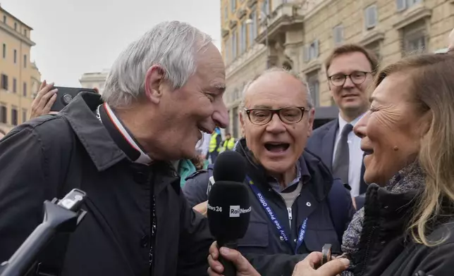 Cardinal Matteo Zuppi, left, is approached by reporters as he arrives for a college of cardinals' meeting, at the Vatican, Monday, April 28, 2025. (AP Photo/Gregorio Borgia)