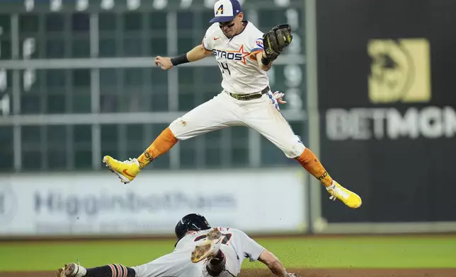 Houston Astros second baseman Mauricio Dubón (14) leaps to catch the throw as Detroit Tigers' Trey Sweeney steals second base during the seventh inning of a baseball game Monday, April 28, 2025, in Houston. (AP Photo/David J. Phillip)