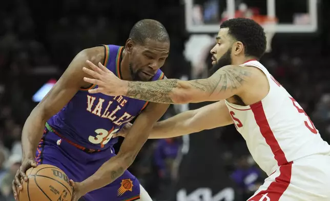 Phoenix Suns forward Kevin Durant (35) gets hit in the face by Houston Rockets guard Fred VanVleet during the first half of an NBA basketball game Sunday, March 30, 2025, in Phoenix. (AP Photo/Ross D. Franklin)