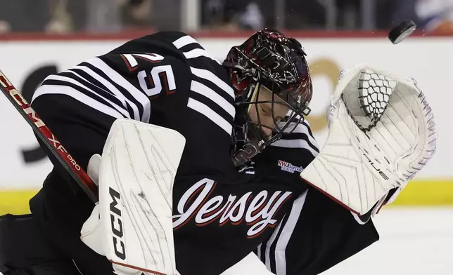 New Jersey Devils goaltender Jacob Markstrom makes a save in the third period of an NHL hockey game against the New York Islanders Sunday, April 13, 2025, in Newark, N.J. (AP Photo/Adam Hunger)