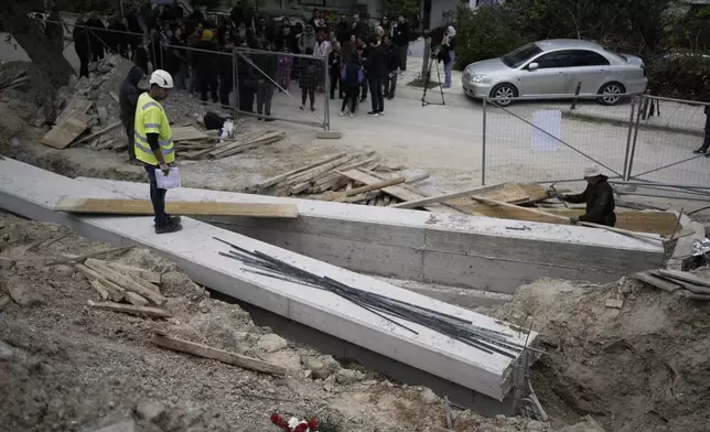 Civil engineer Ηaris Charismiadis leads the redevelopment of a square that uncovered mass graves with remains believed to be dozens of prisoners executed during or after the Greek Civil War as members of the Greek Communist Party visit the site in Thessaloniki, Greece, Saturday, April 12, 2025. (AP Photo/Thanassis Stavrakis)