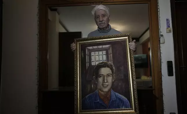 Agapios Sachinis holds a portrait of his uncle, a prisoner executed in the Greek Civil War, in Thessaloniki, Greece, on Saturday, April 12, 2025. (AP Photo/Thanassis Stavrakis)