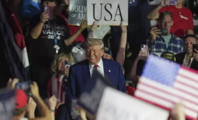President Donald Trump arrives to speak on his first 100 days at Macomb County Community College Sports Expo Center, Tuesday, April 29, 2025, in Warren, Mich. (AP Photo/Paul Sancya)