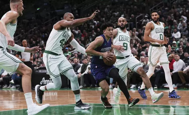 Charlotte Hornets guard KJ Simpson, center, drives to the basket against the Boston Celtics during the first half of an NBA basketball game, Friday, April 11, 2025, in Boston. (AP Photo/Charles Krupa)