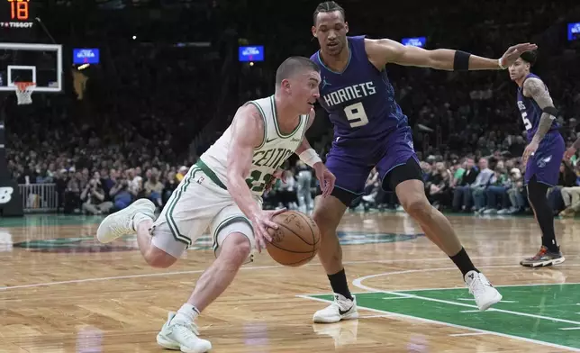 Boston Celtics guard Payton Pritchard, left, drives to the basket against Charlotte Hornets guard Wendell Moore Jr. (9) during the second half of an NBA basketball game, Friday, April 11, 2025, in Boston. (AP Photo/Charles Krupa)